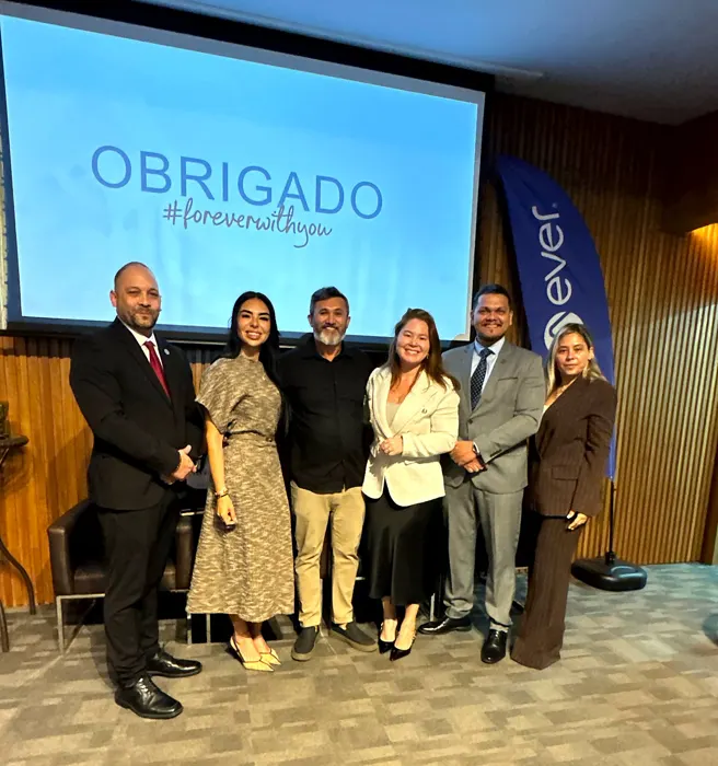 Grupo reunido diante do telão com a mensagem Obrigado no evento da Ever